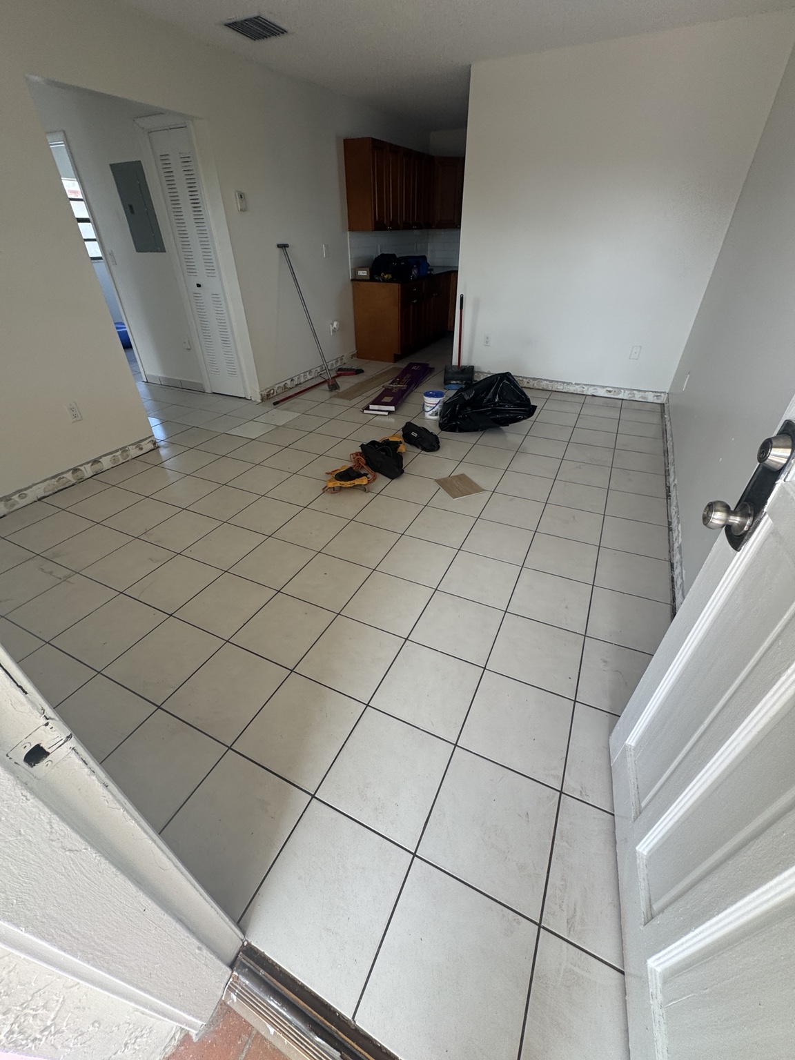 Living and dining room before installation with existing light tile flooring.