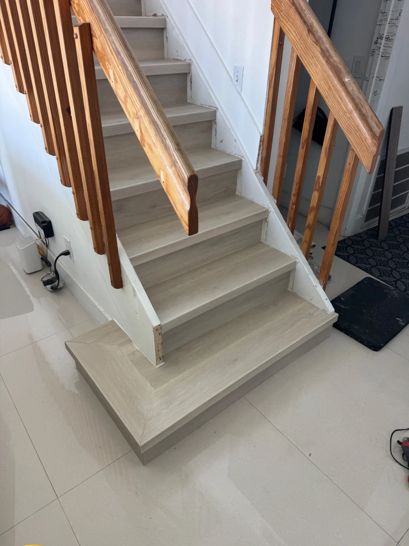 Close-up detail of the extended first stair tread by Colors Wood Floor Corp.
