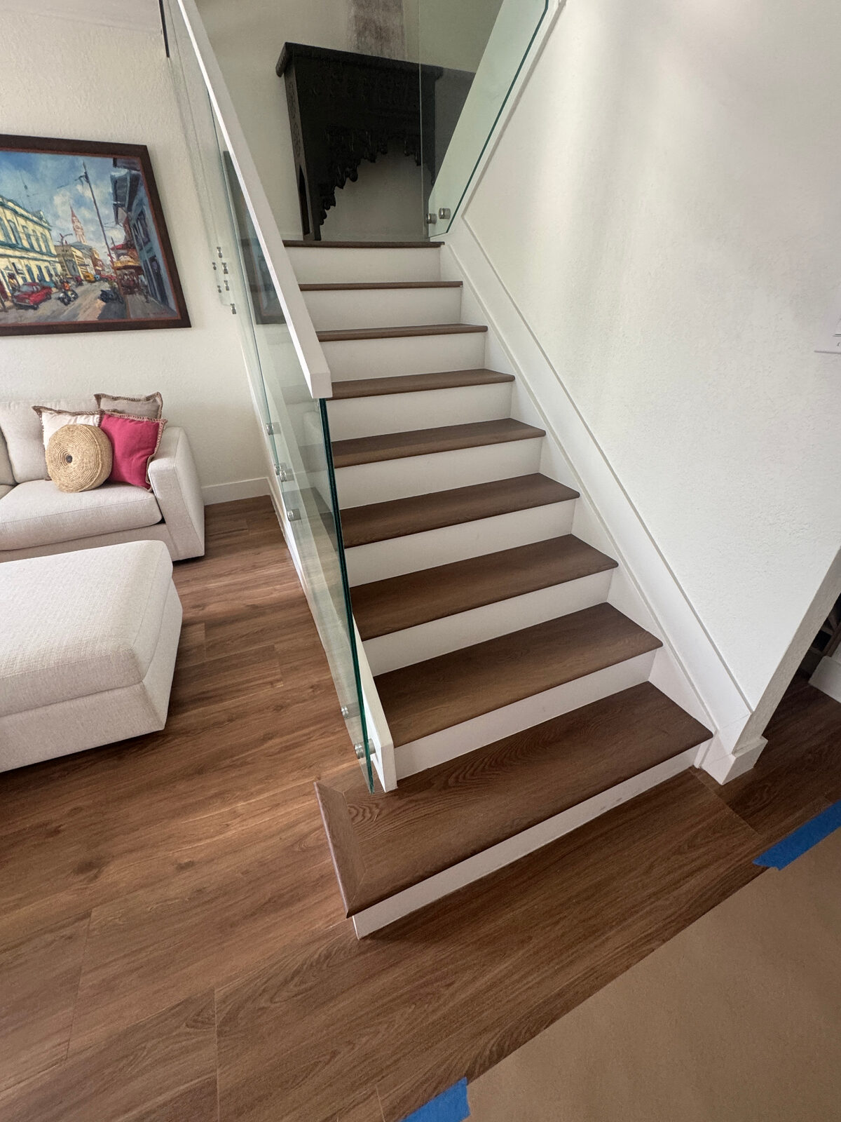Custom dark wood staircase installation with matching premium flooring