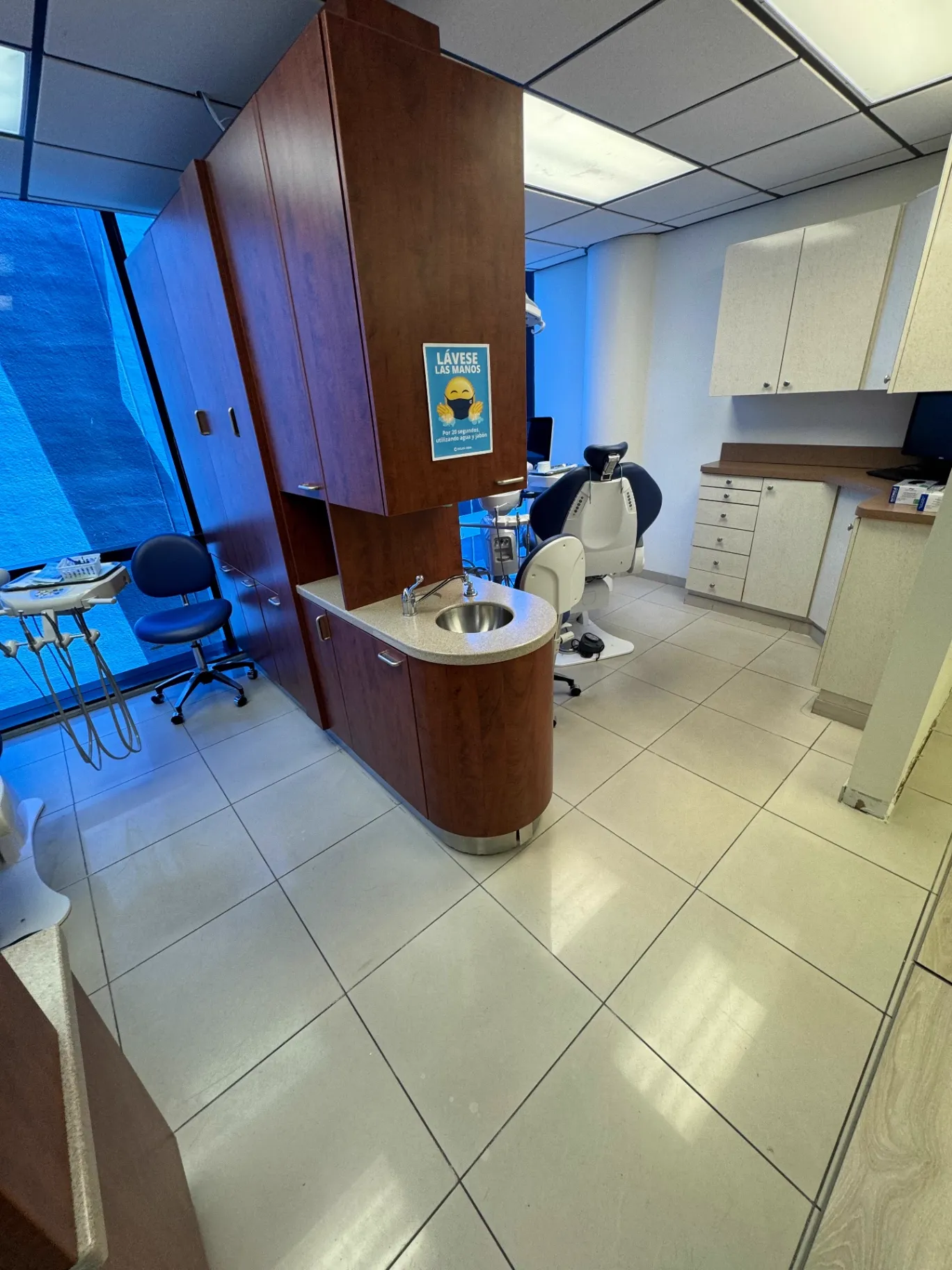 Before photo — dental treatment room in Miami with the original white tile flooring still in place, prior to installation by Colors Wood Floor Corp.