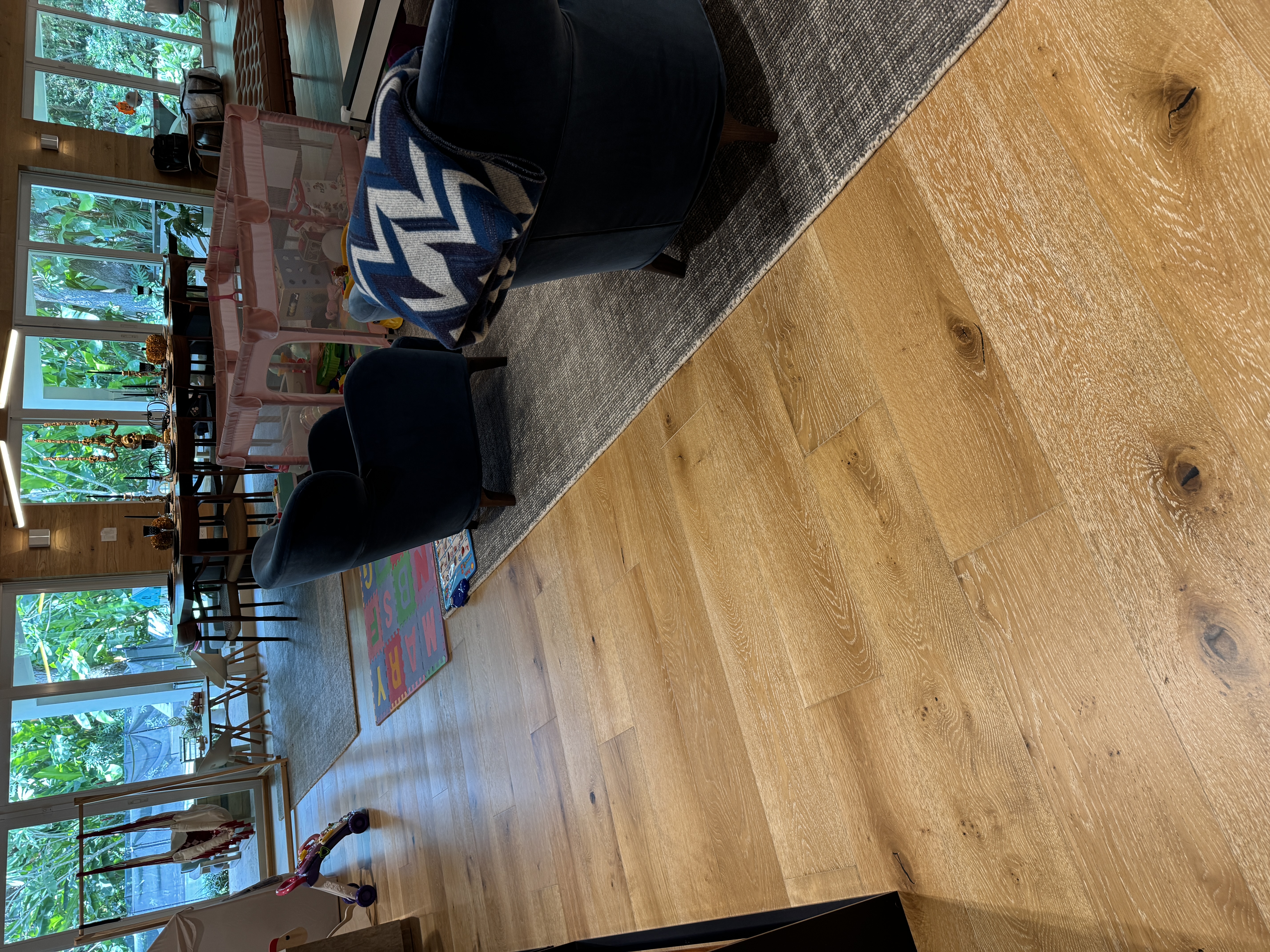 Angled view of the completed living room with engineered wood flooring in a Pinecrest, FL home.
