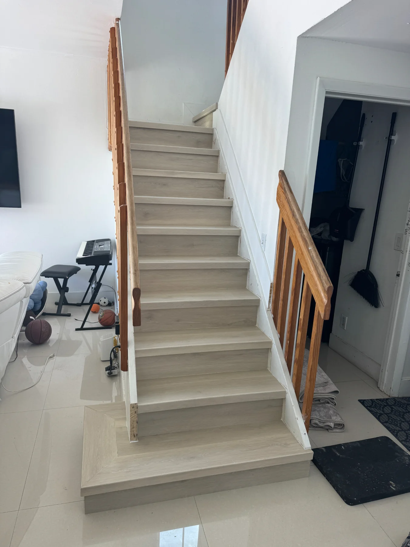Supporting front view of the completed staircase with the light wood-look finish by Colors Wood Floor Corp.