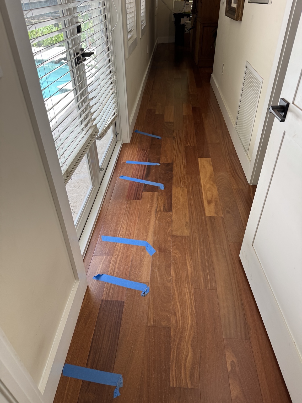 Brazilian Cherry hardwood floor sections marked for professional evaluation.
