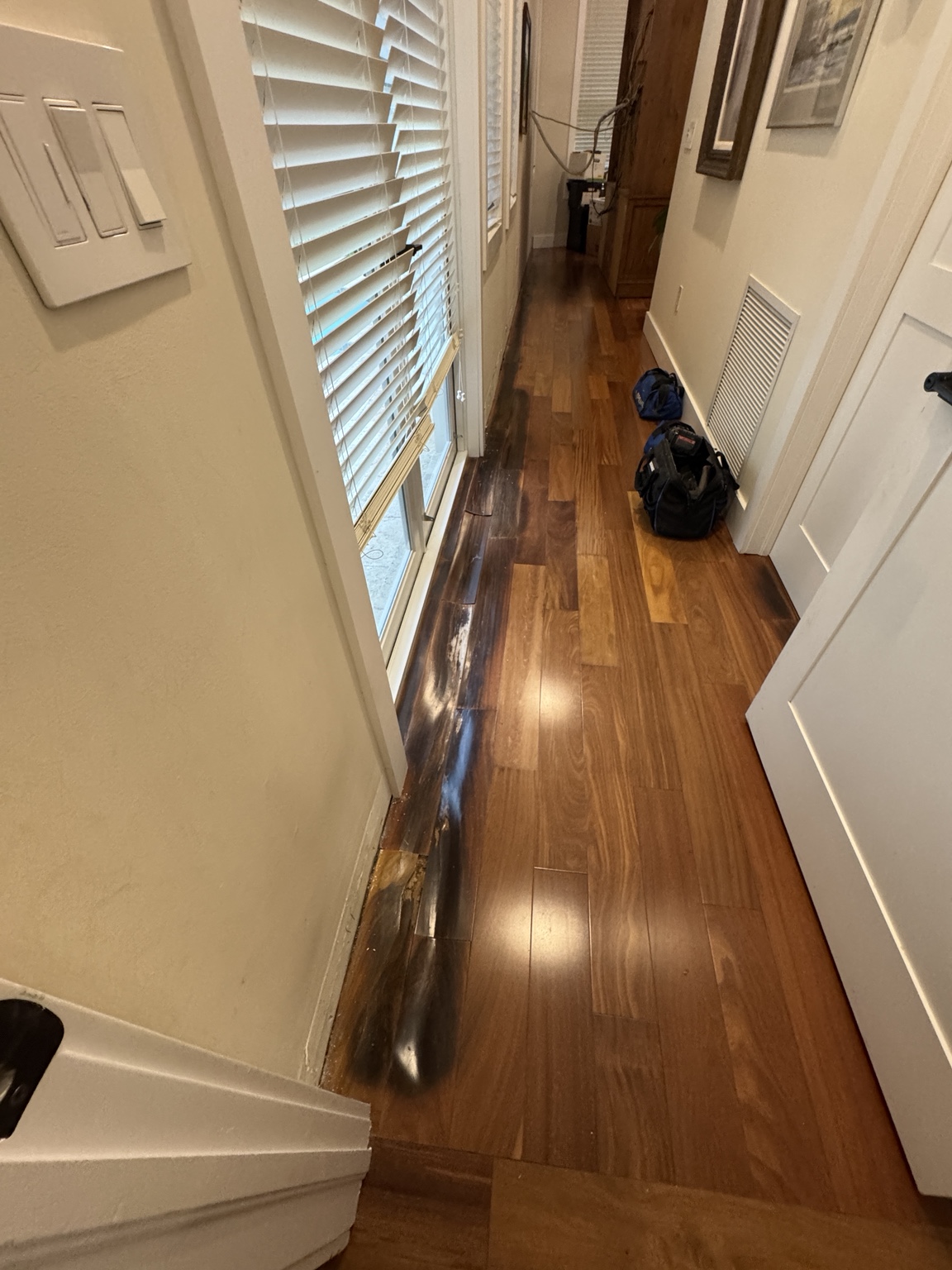 Damaged Brazilian Cherry hardwood planks before professional floor repair.