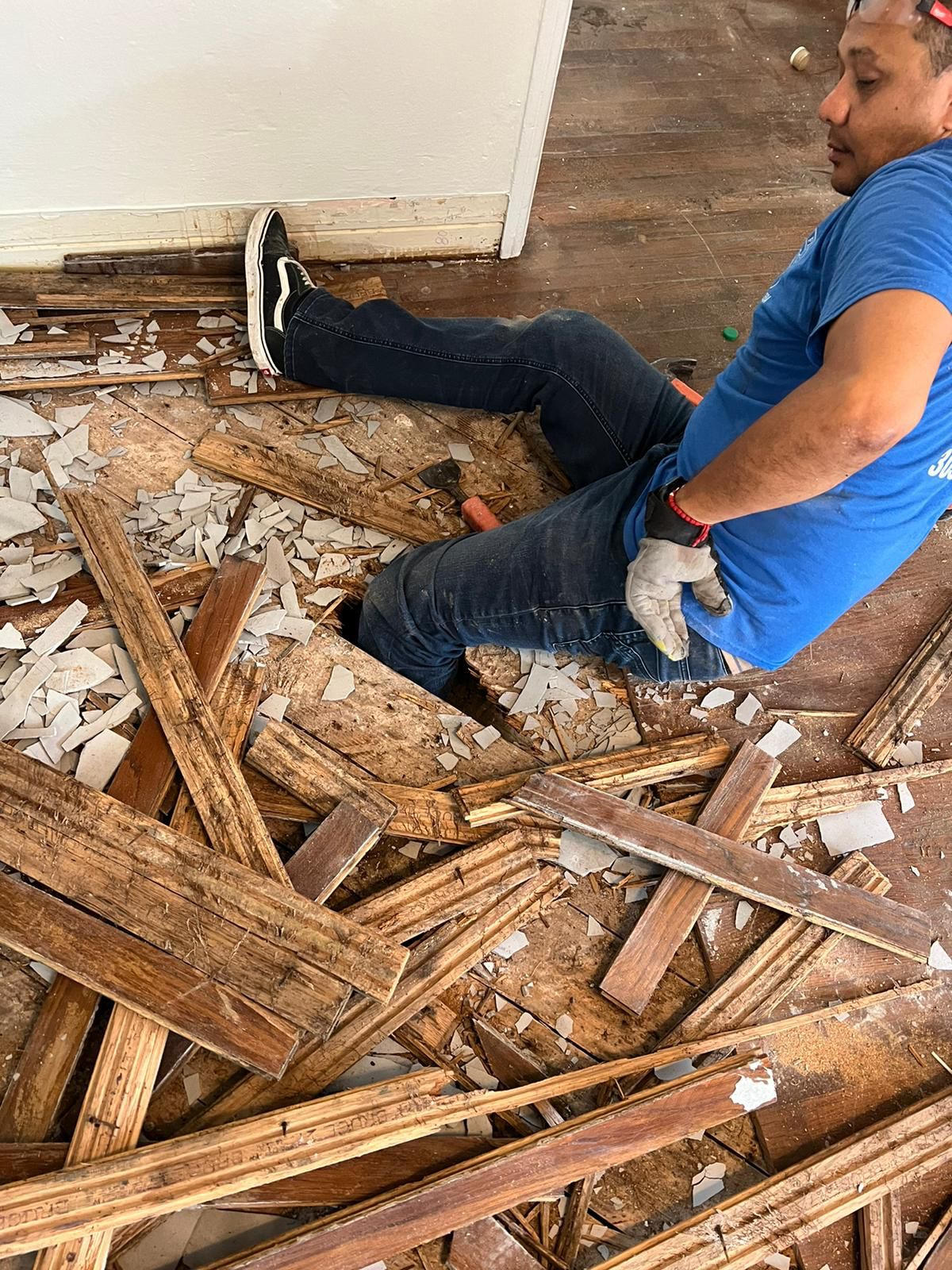 Technician removing the damaged Red Oak hardwood flooring during the repair project in Miami Beach