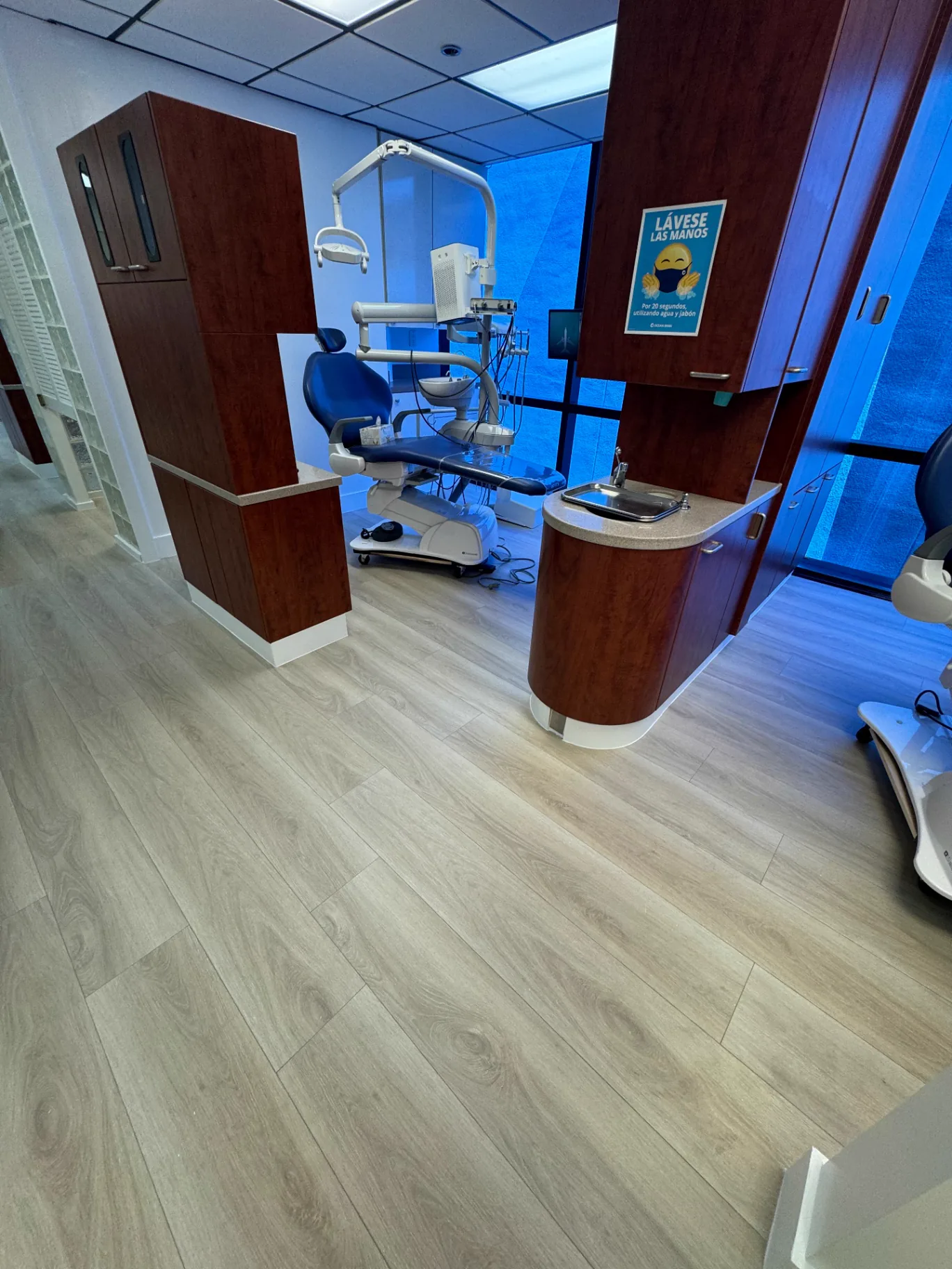 Dental treatment room in Miami with light warm oak wood-look flooring installed by Colors Wood Floor Corp.