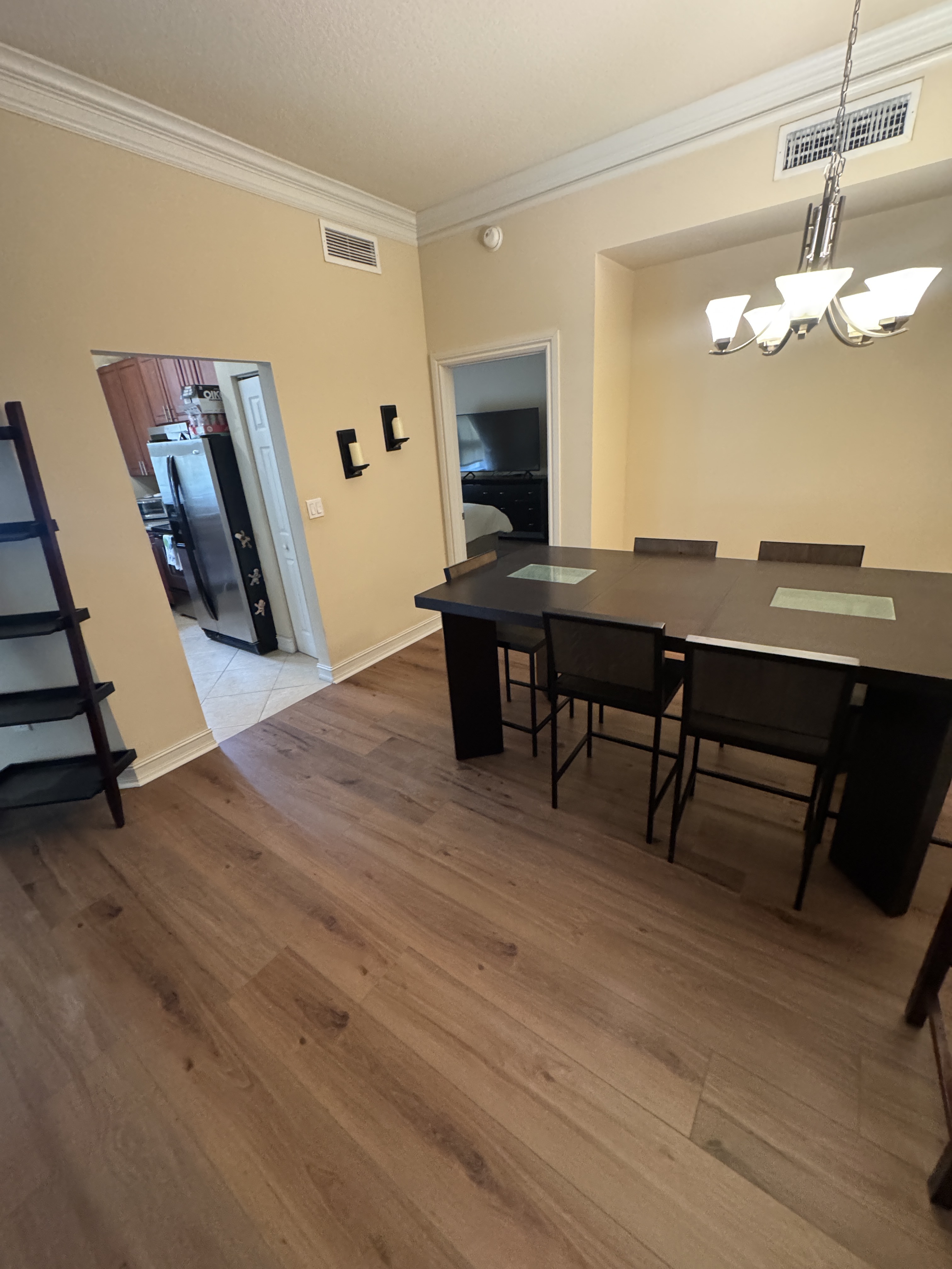Completed vinyl wood-look flooring in the dining room of an Aventura, FL condo, with the dining table and chairs in place.