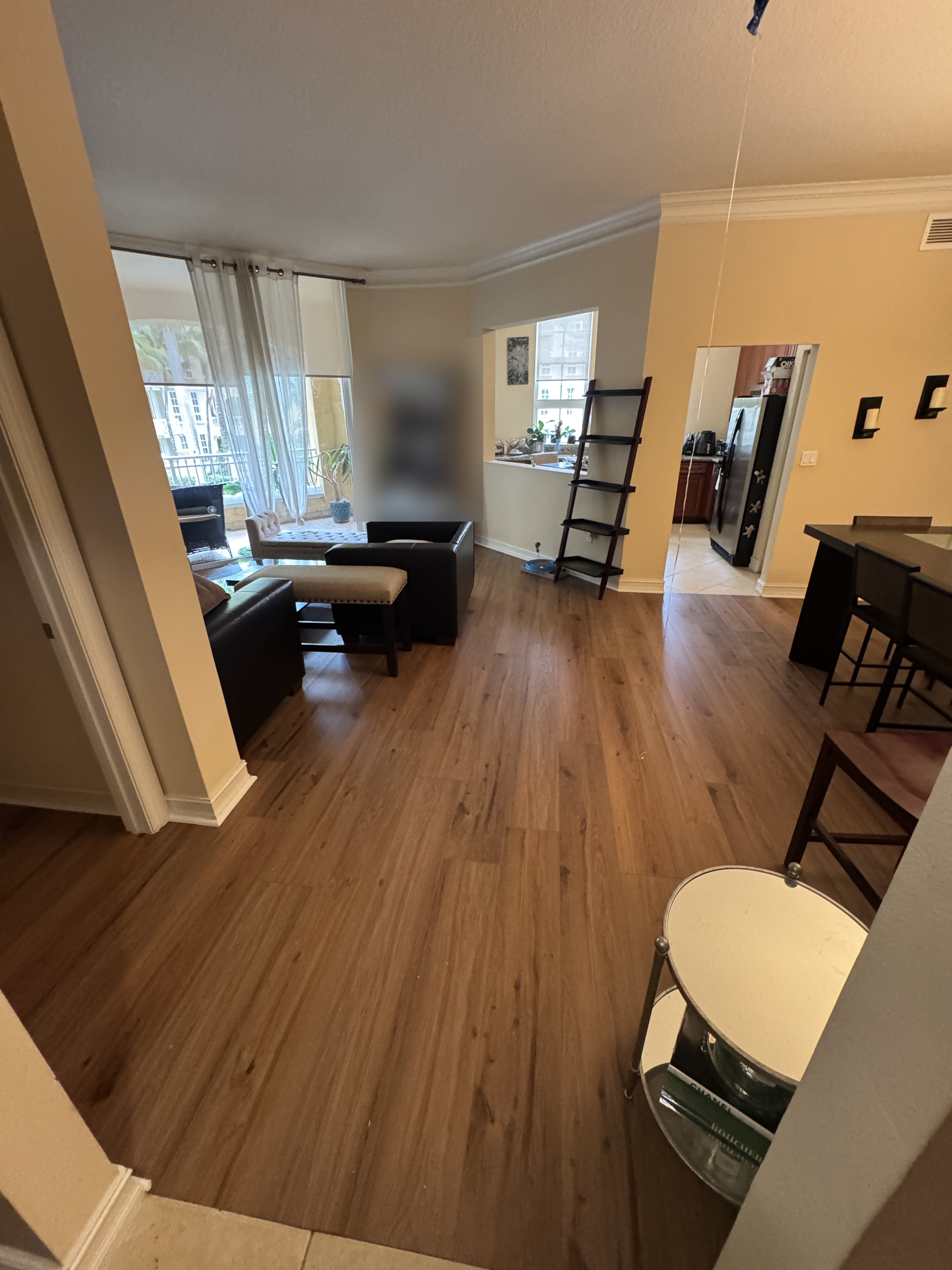 Vinyl wood-look flooring through the hallway between the living room, dining room and kitchen area of an Aventura, FL condo.