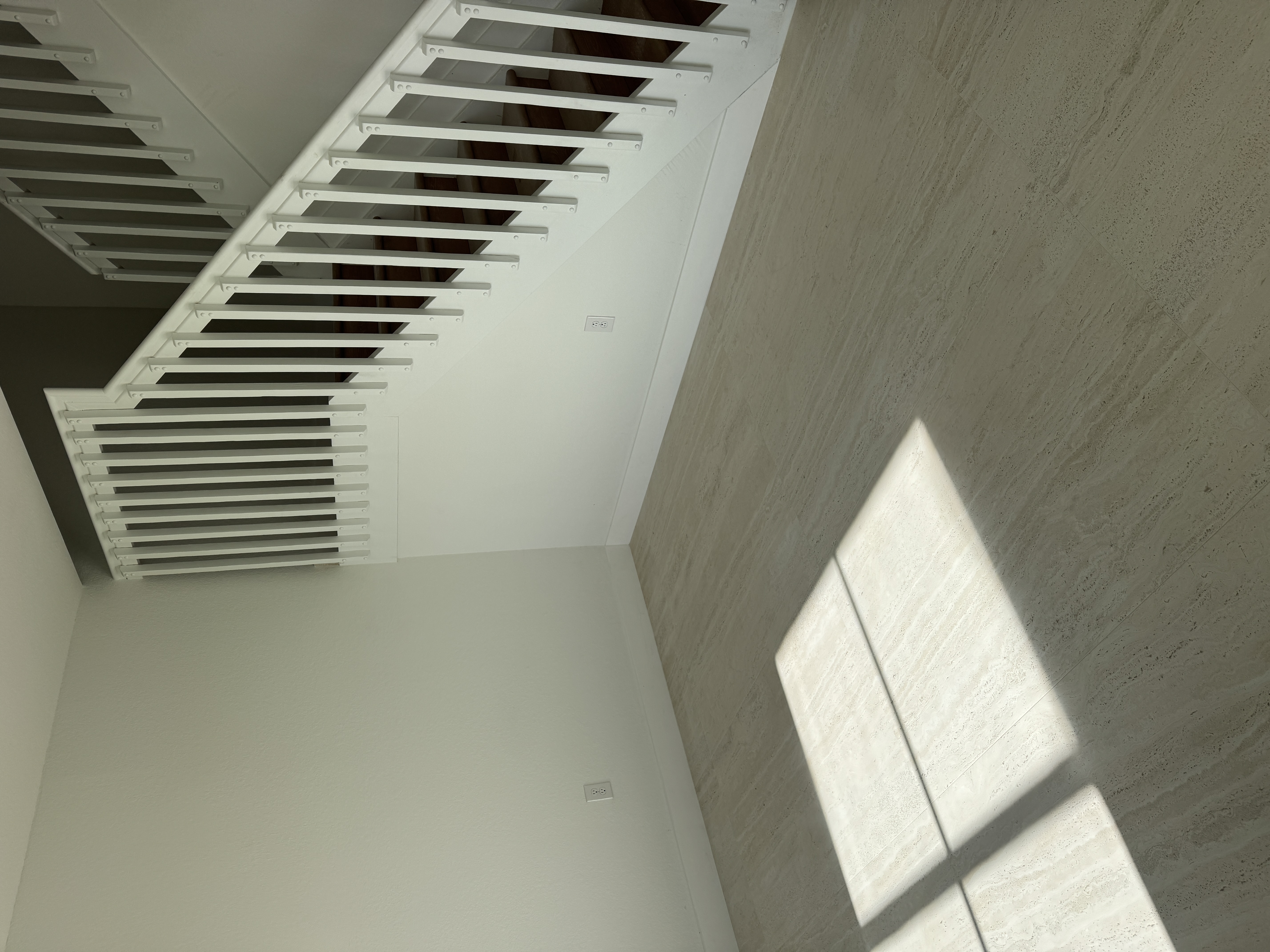 Wide view of staircase area before baseboard installation, Miami interior renovation