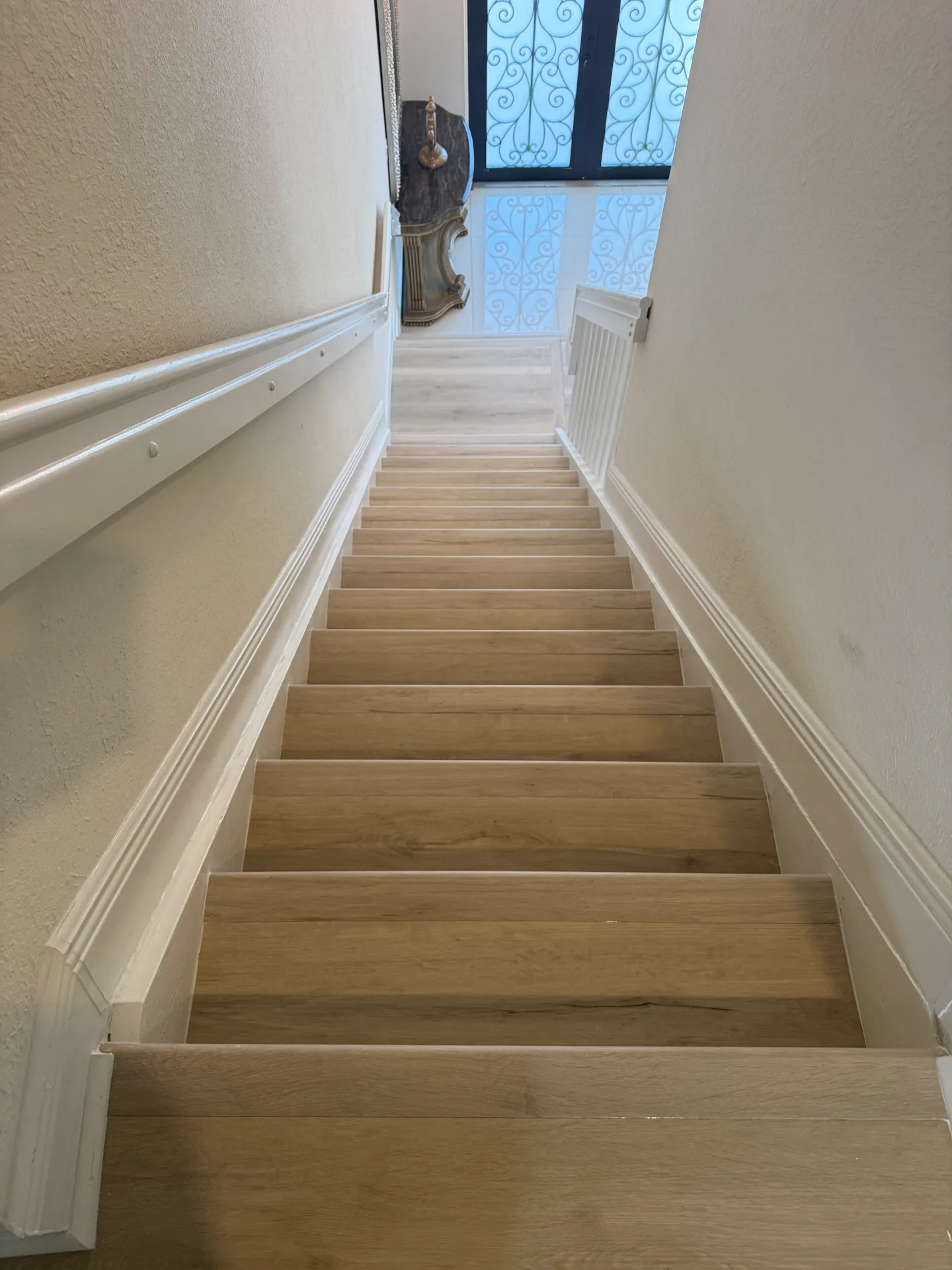 Additional staircase area in the same home finished in a warmer natural wood-look tone — supporting view.