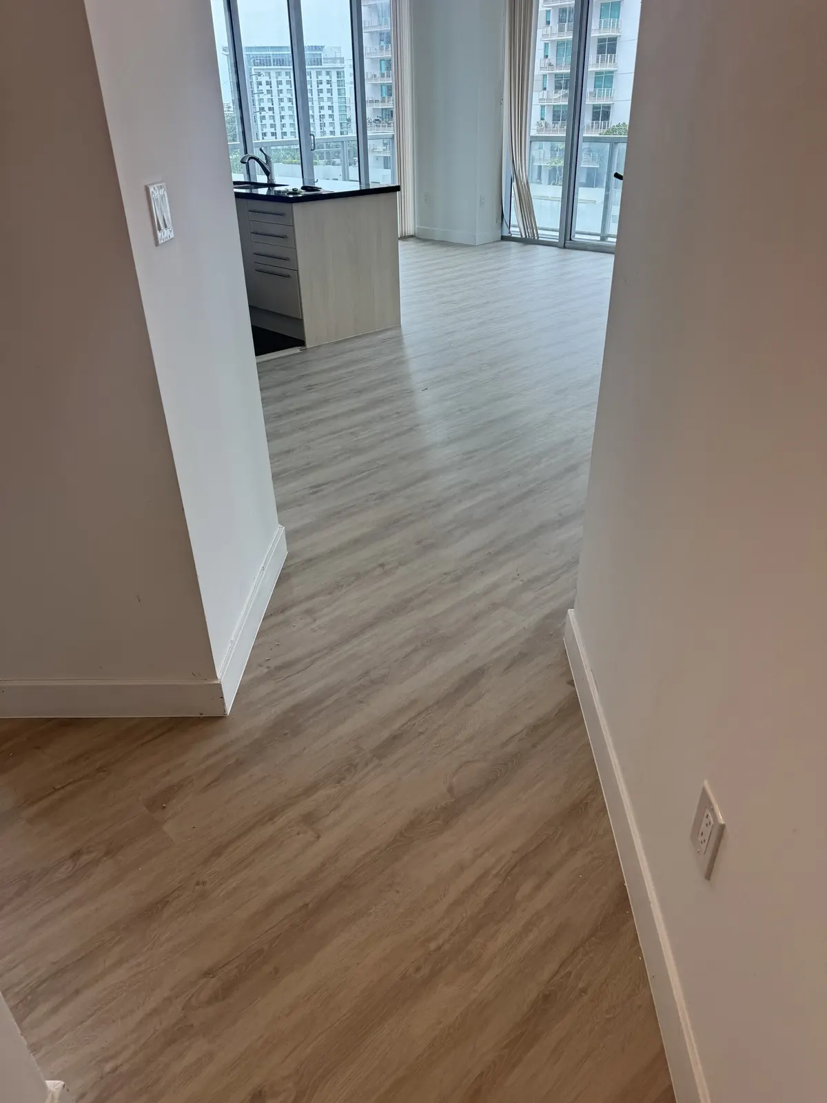 Finished Rio Novo Villa Arcadio vinyl flooring through the hallway toward the living area at Axis on Brickell.