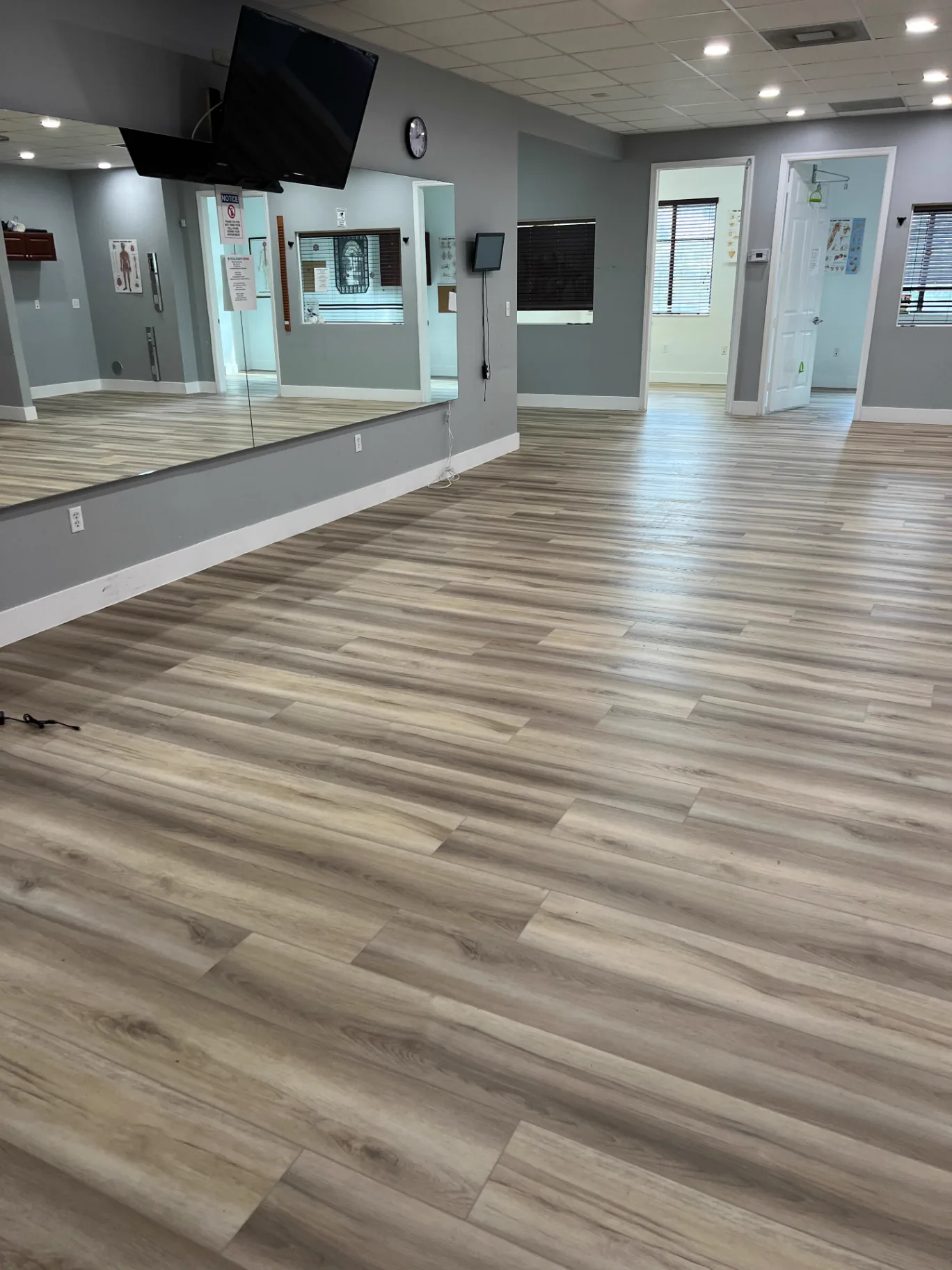 Wellness clinic open therapy area in Miami with warm-toned wood-look commercial flooring installed by Colors Wood Floor Corp.