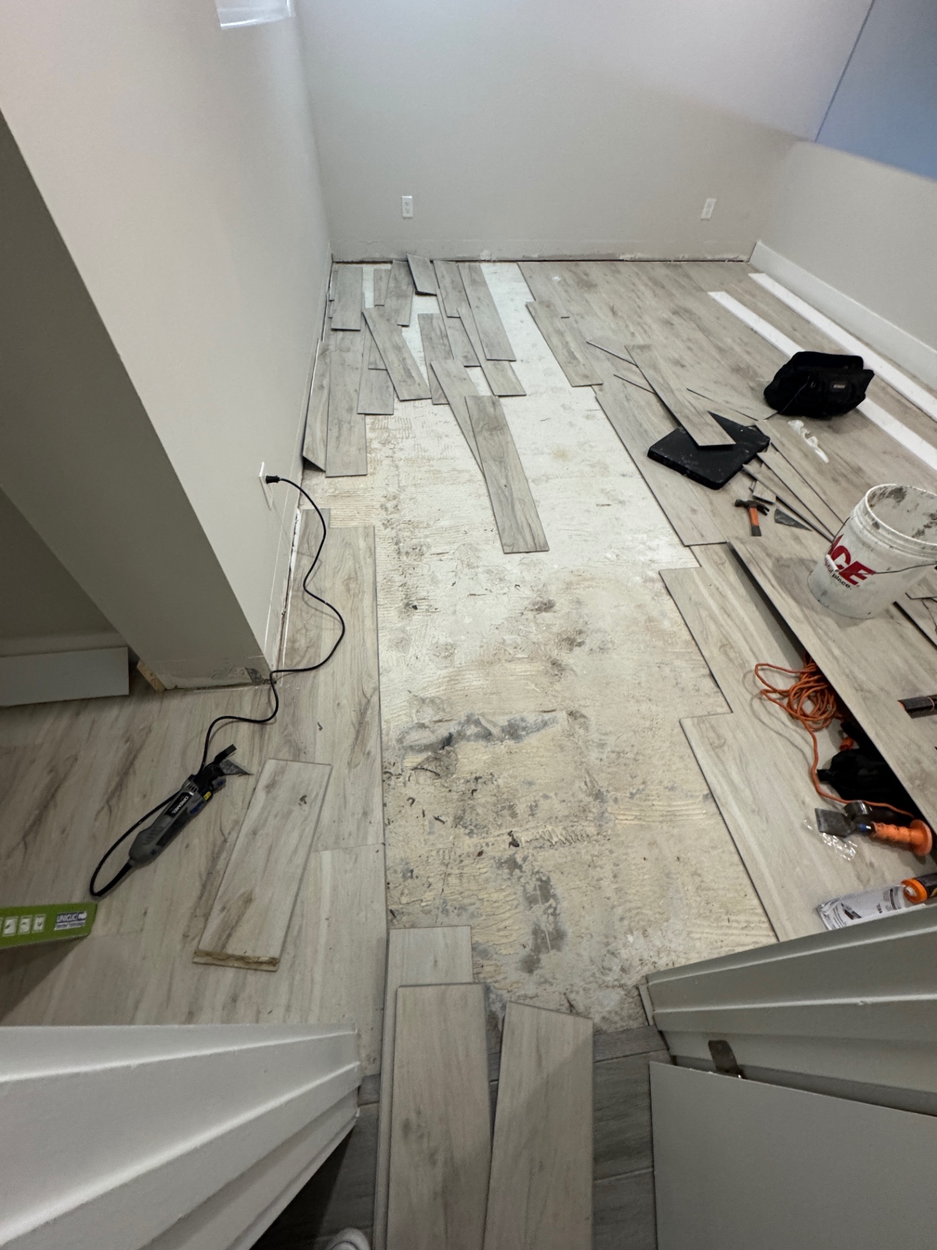 Flooring reinstallation in progress after correcting the existing installation, tools staged on site.