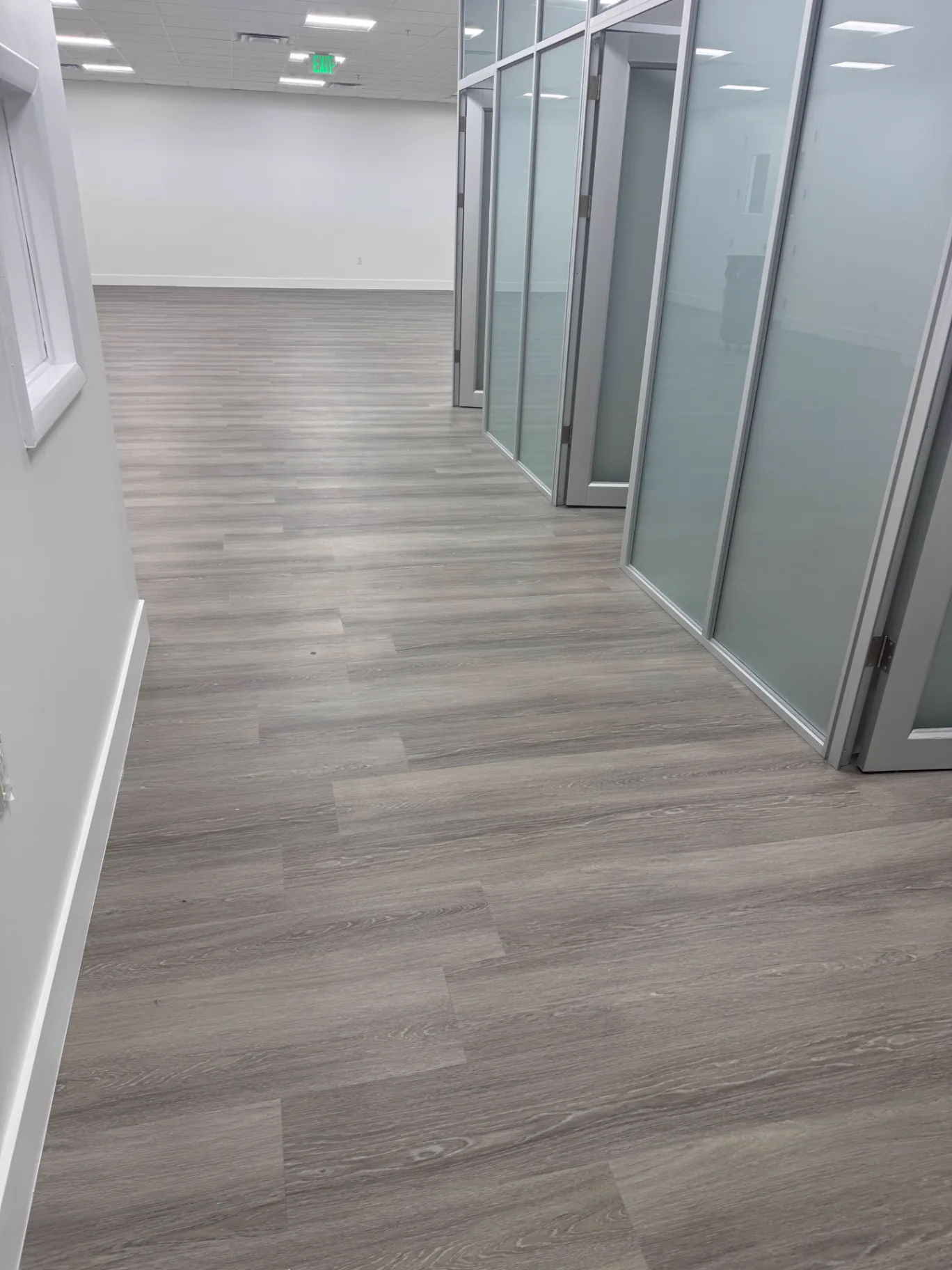 Commercial office hallway in Miami finished with warm-gray wood-look flooring installed by Colors Wood Floor Corp.