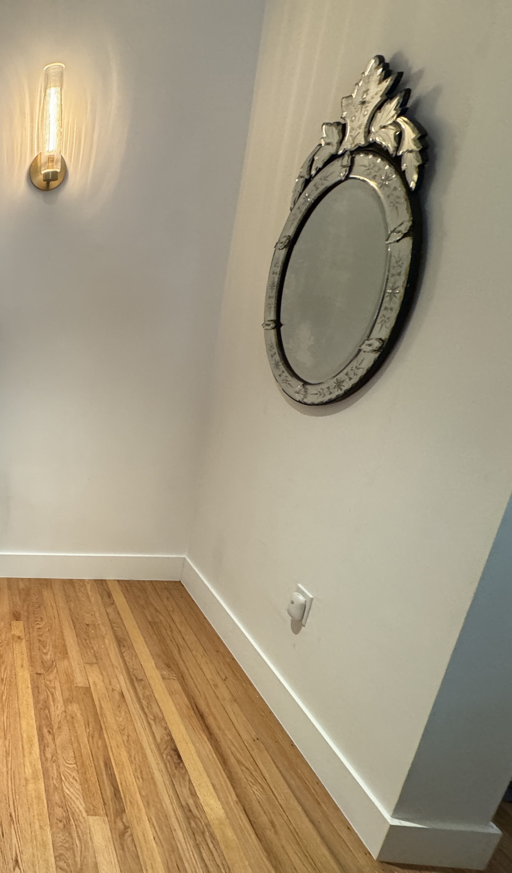 Same living room after new white baseboard trim installation, finished wall-to-floor lines.