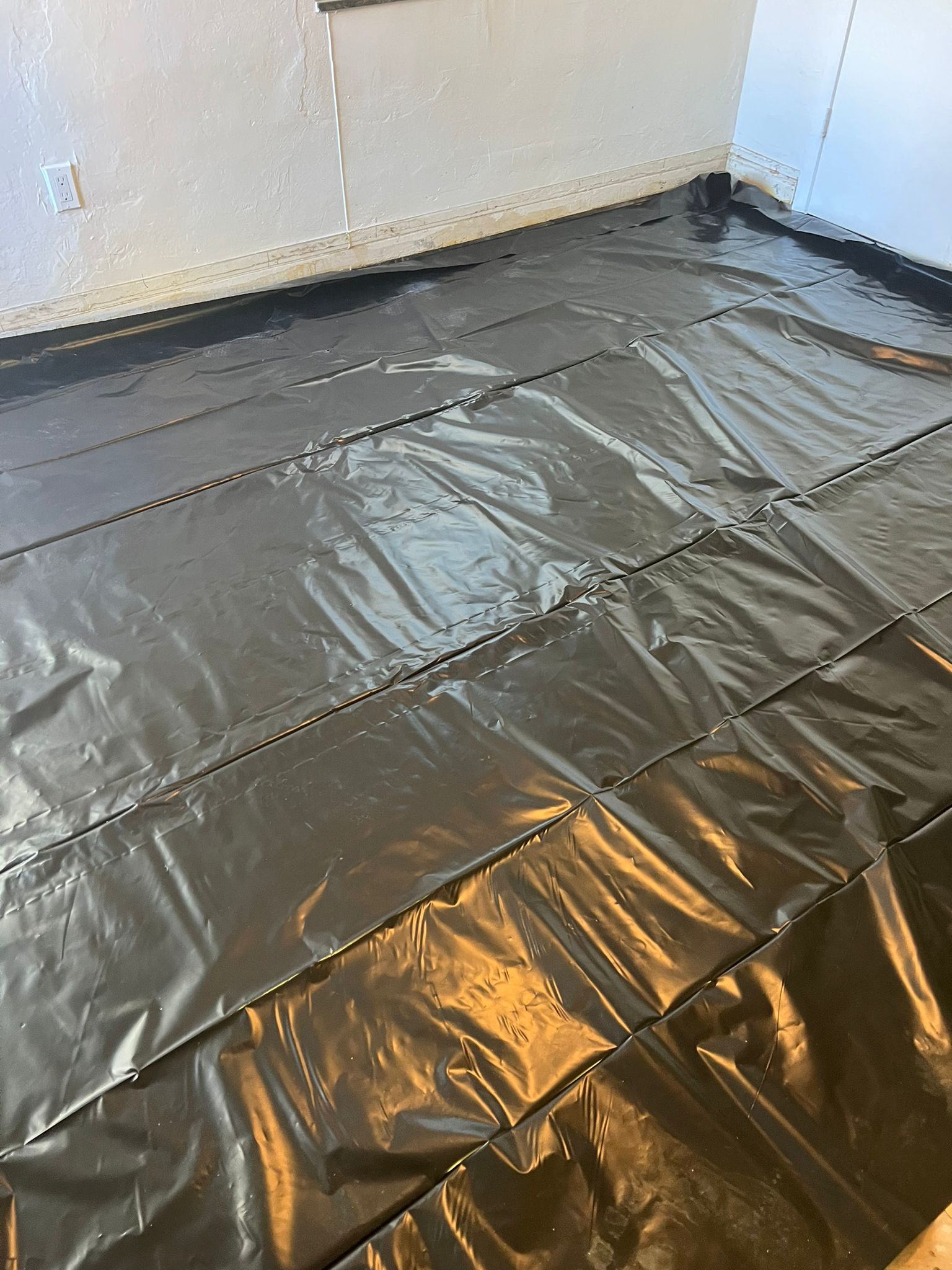 Plastic moisture barrier installed over the repaired subfloor before the plywood base, Miami Beach