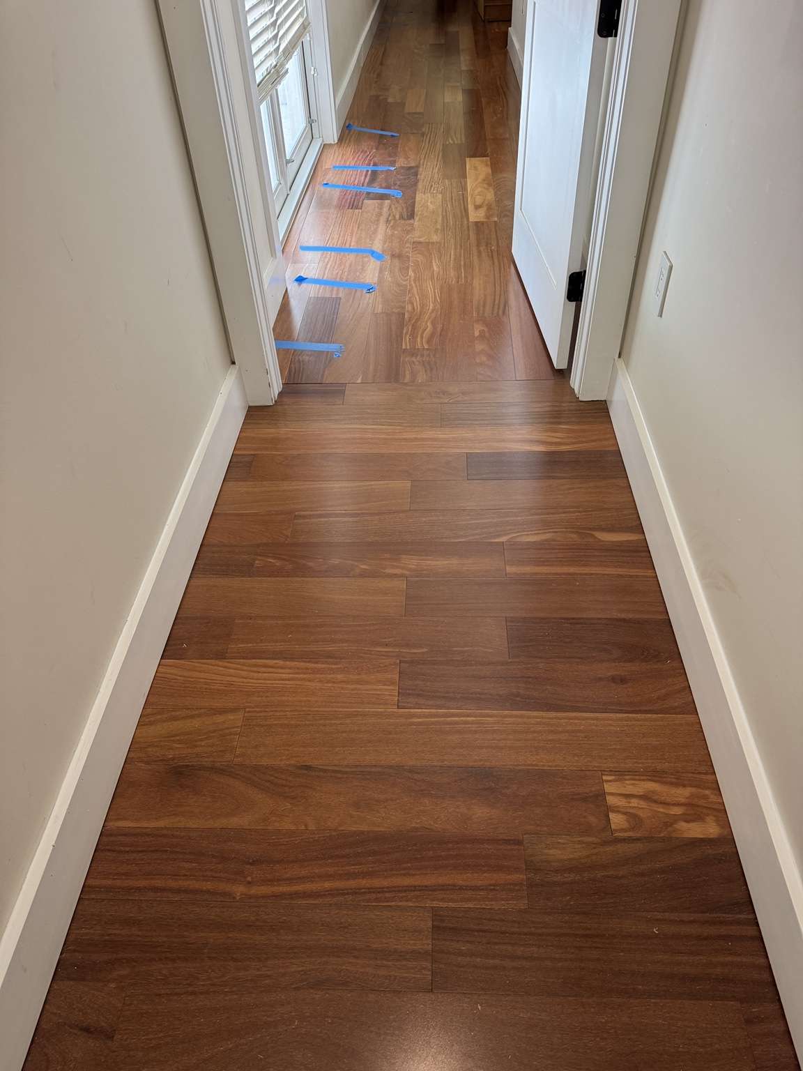 Repaired Brazilian Cherry wood flooring integrated with the existing hallway.