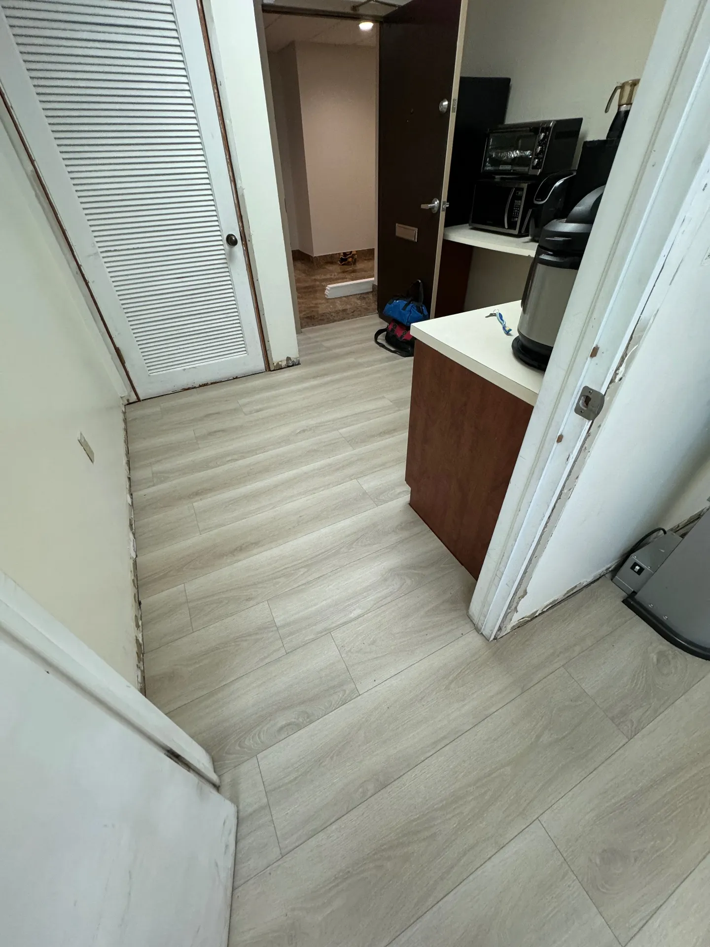 In-progress photo — dental office break room in Miami with the new commercial wood-look flooring installed by Colors Wood Floor Corp, before baseboards were reinstalled.
