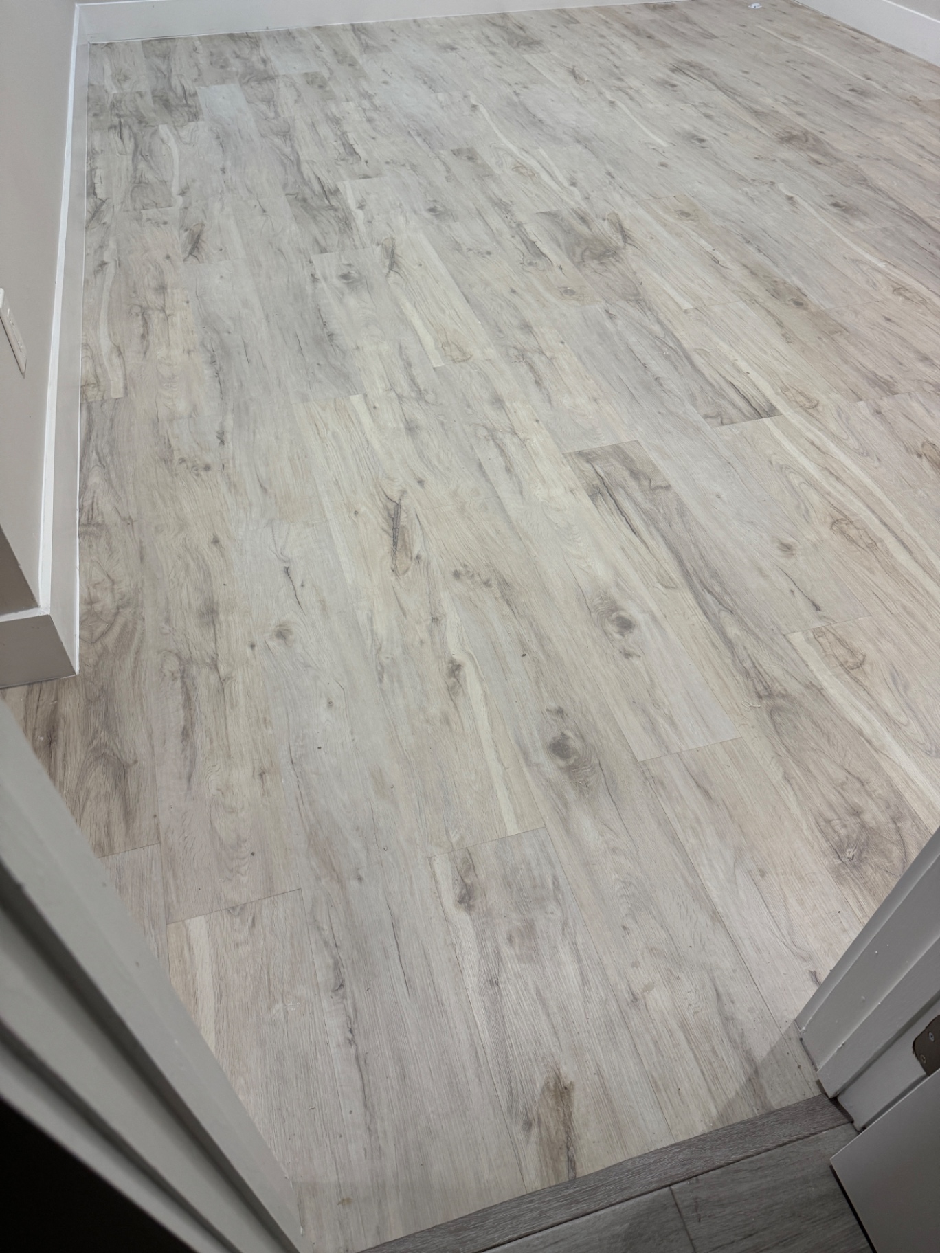 Completed flooring installation correction: aligned planks and finished perimeters throughout the repaired area.