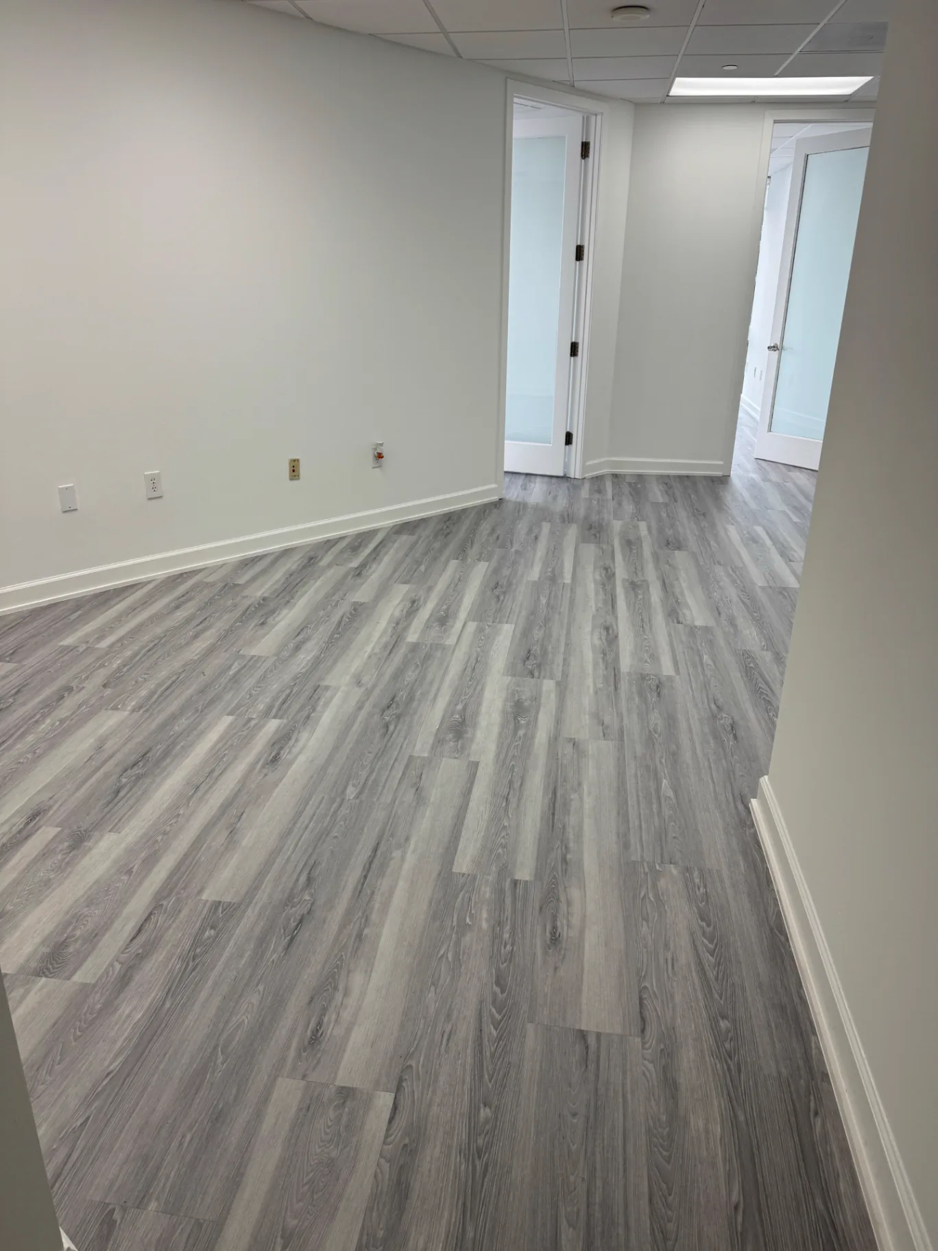 Private office in Miami with a light gray veined wood-look flooring installed by Colors Wood Floor Corp.