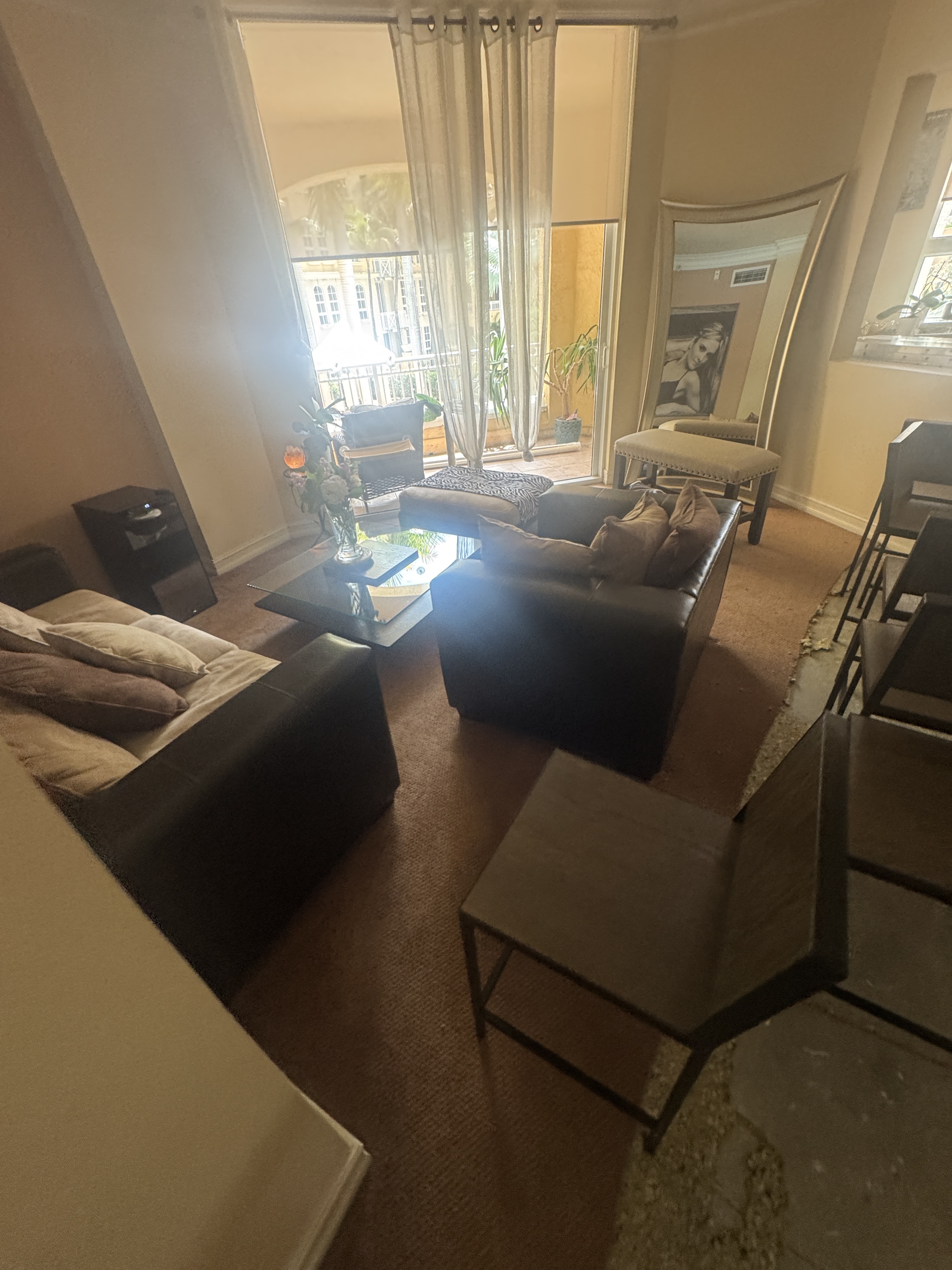 Living room before vinyl wood-look flooring installation in an Aventura, FL condo, with the existing carpet visible.