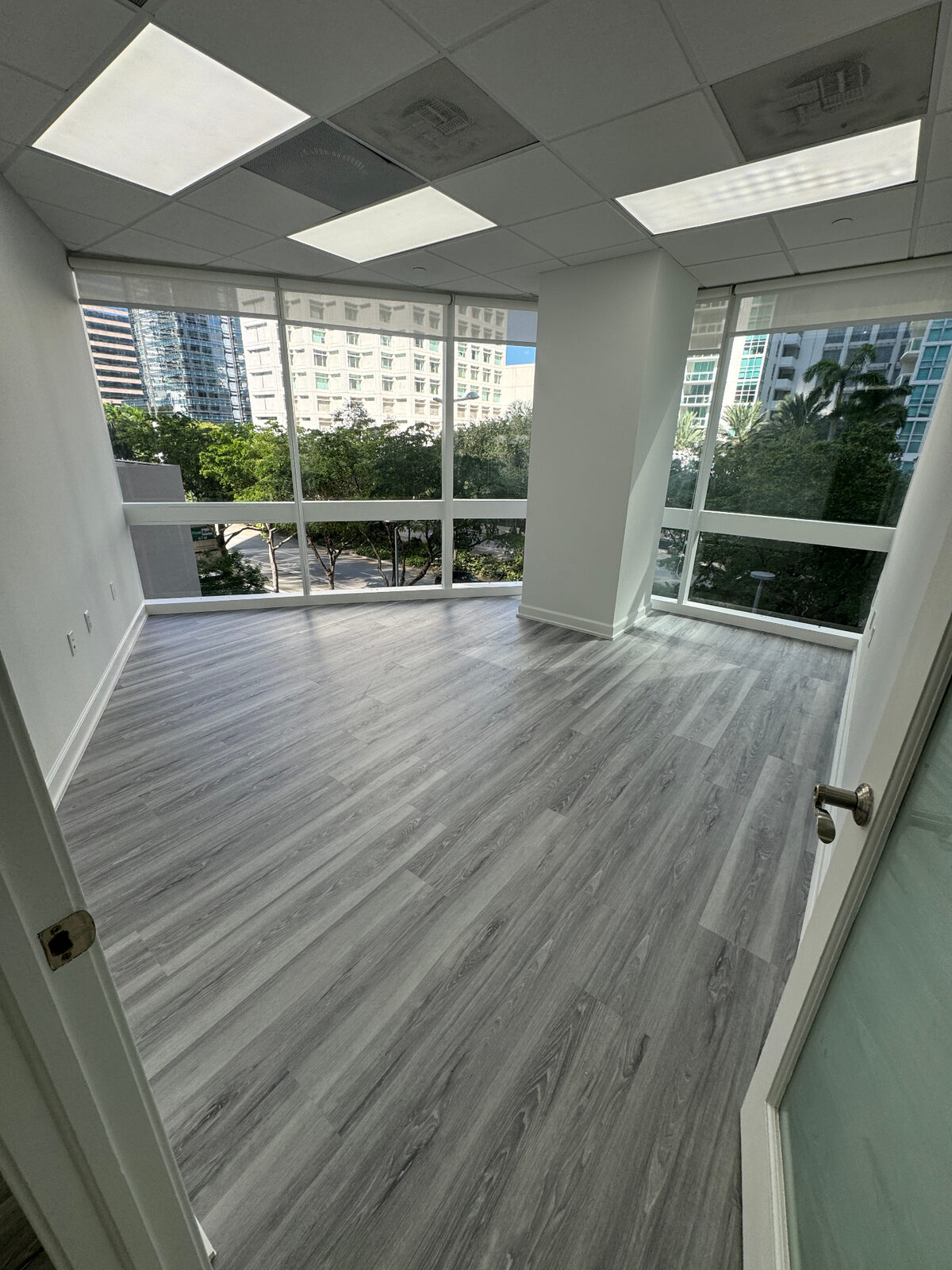Light gray luxury vinyl flooring installed in a bright commercial office suite