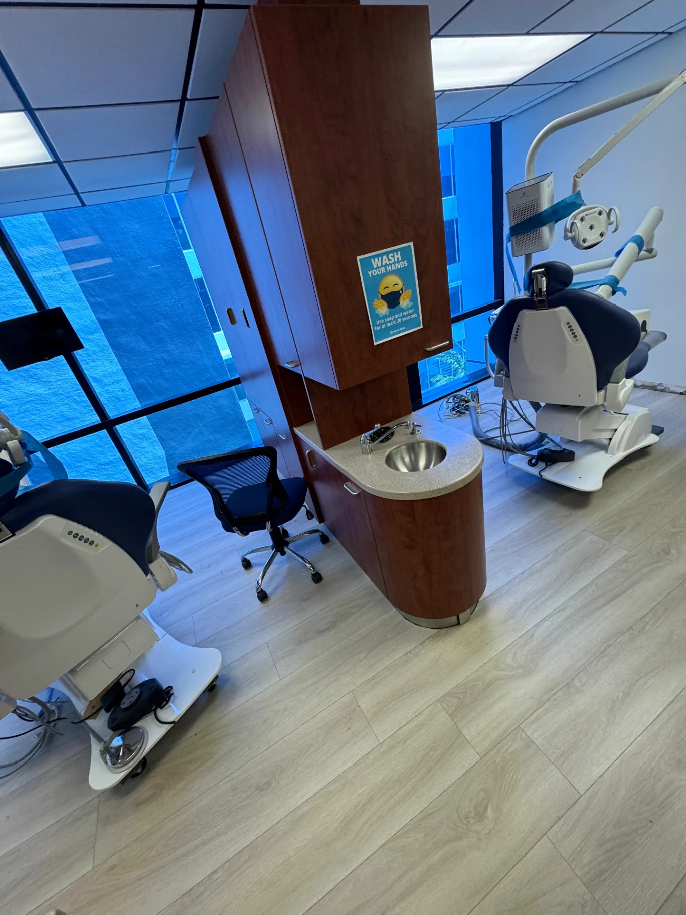 Two-chair dental operatory in Miami with light warm oak wood-look commercial flooring installed by Colors Wood Floor Corp.