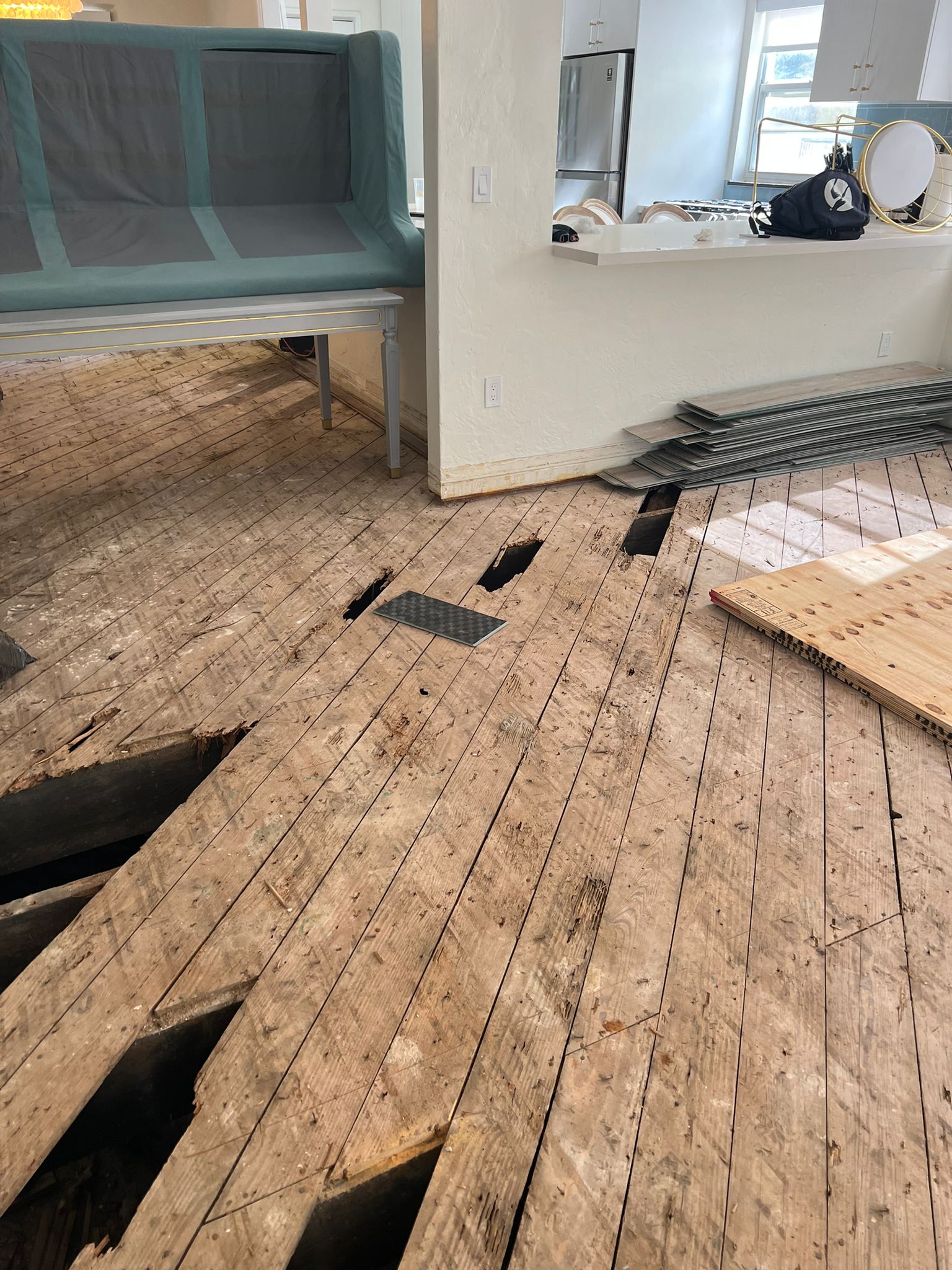 Original wood subfloor showing multiple holes from old termite damage before repair, Miami Beach home