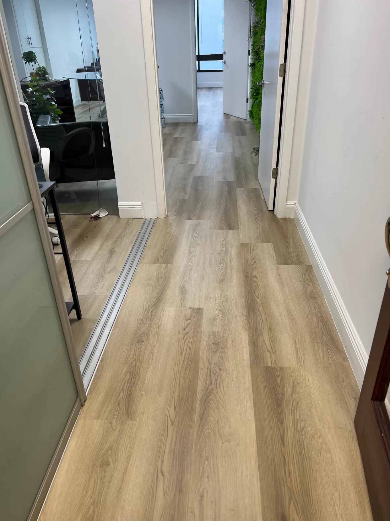 Executive suite hallway in Miami with light warm oak wood-look flooring installed by Colors Wood Floor Corp.