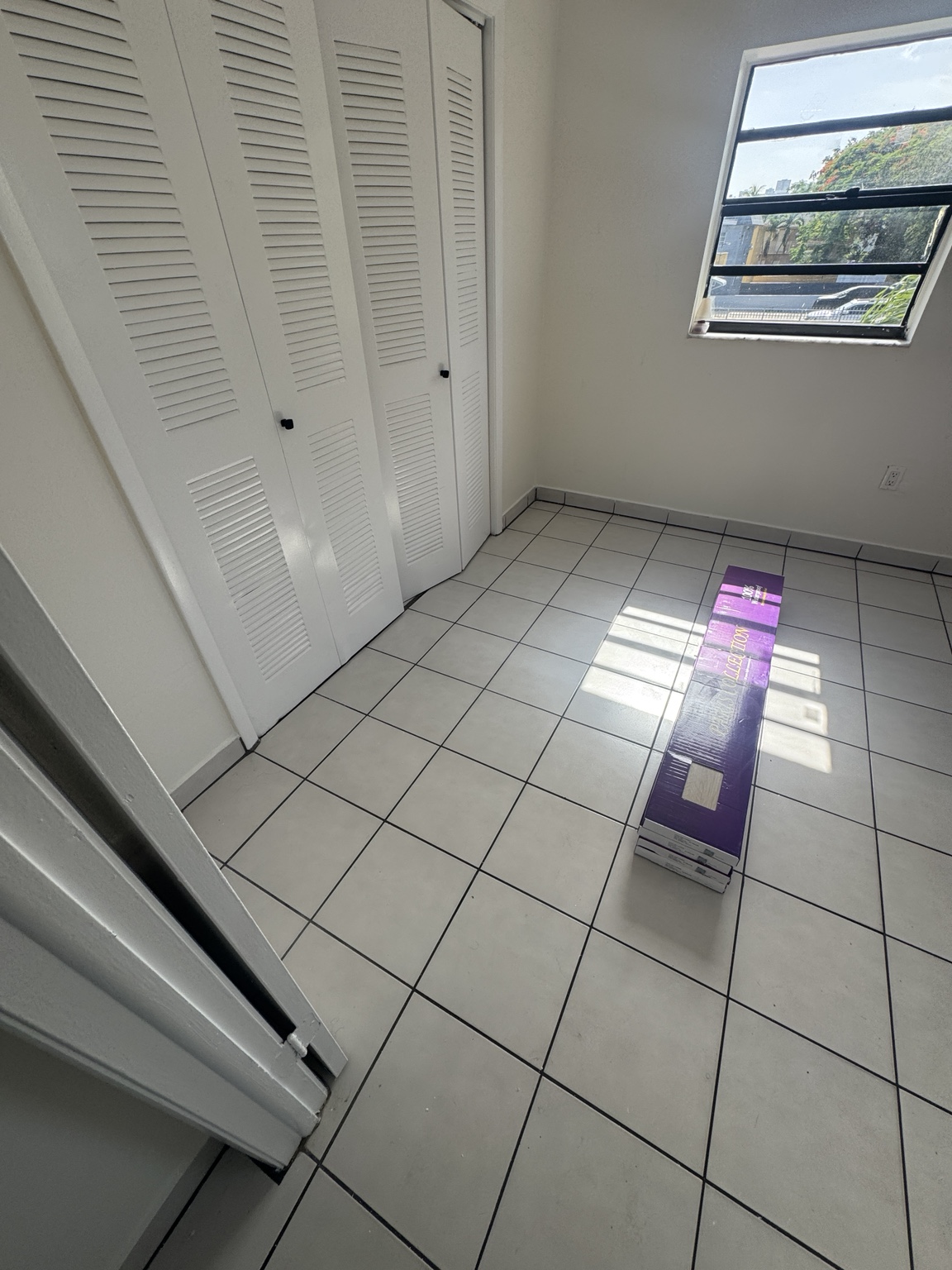 Waterproof light wood-look vinyl flooring boxes staged in a bedroom during installation prep.