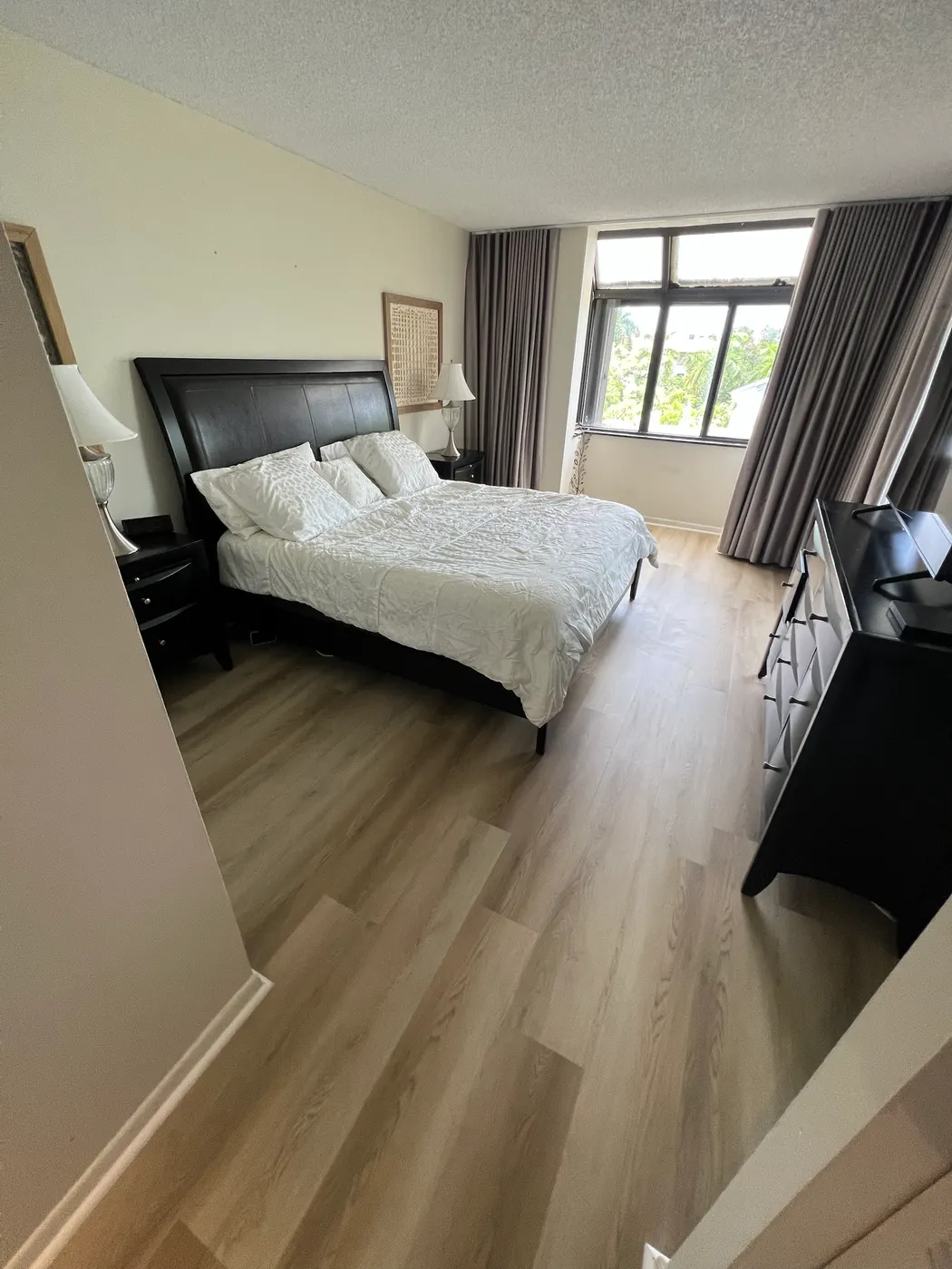 Bedroom with new light wood-look plank flooring installed by Colors Wood Floor