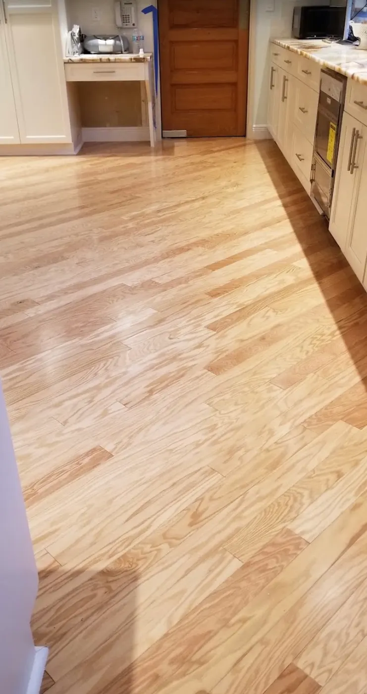 Light-toned wood flooring installed through a kitchen by Colors Wood Floor