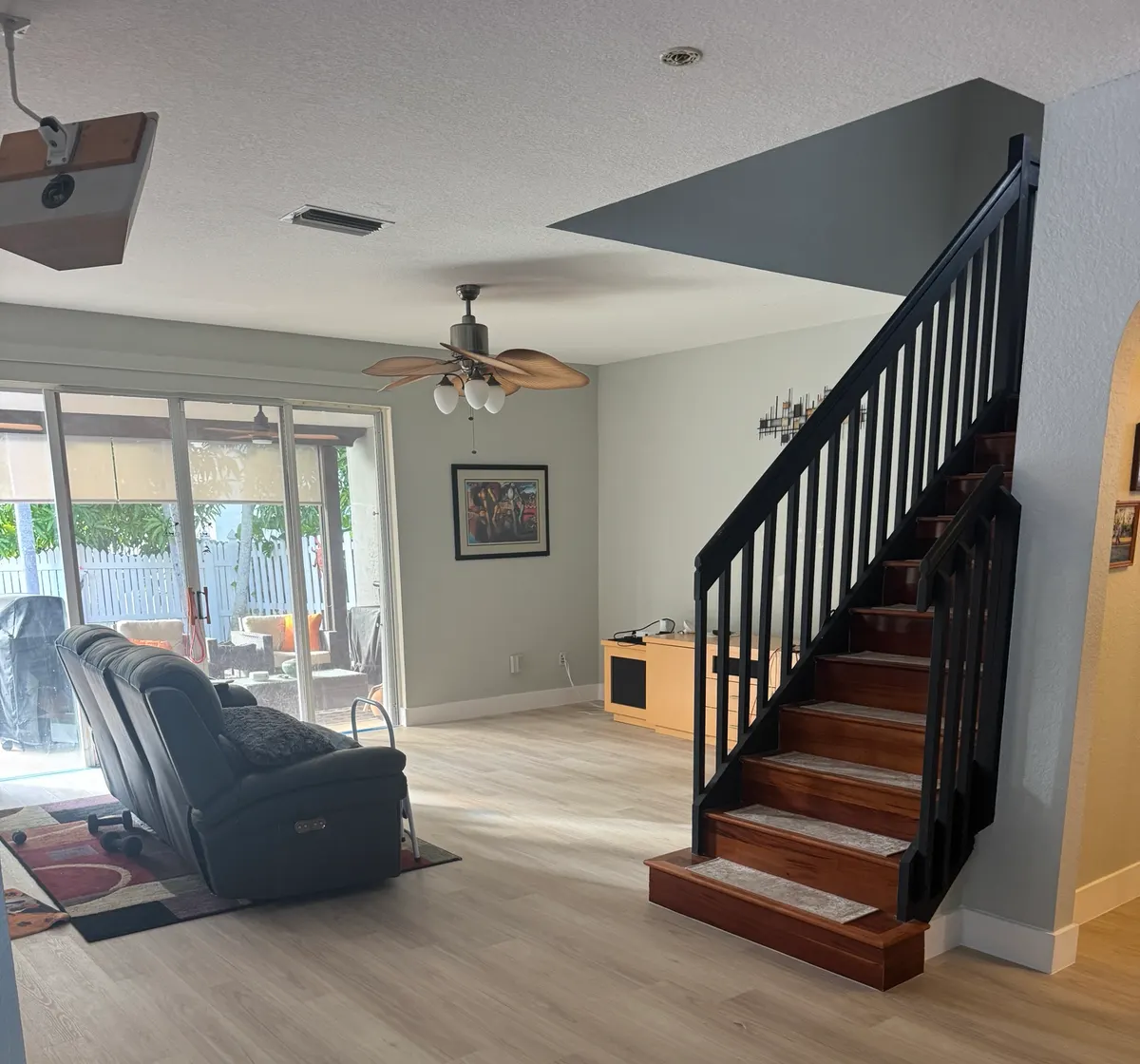 The same living room after Colors Wood Floor replaced the tile with light wood-look plank flooring and new white baseboards